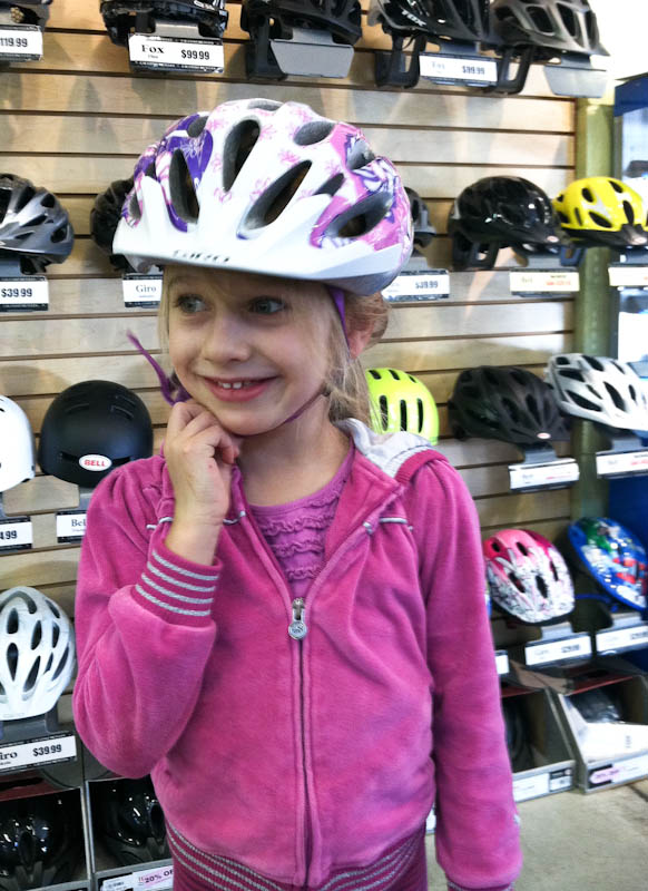 Skylar smiling in white bike helmet with pink accents and flowers