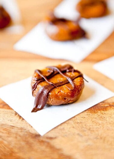 Gourmet donut topped with chocolate on a white napkin.