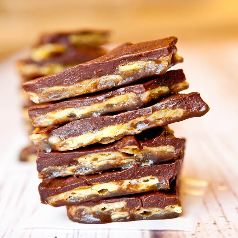 A stack of chocolate-covered toffee bars with nuts.