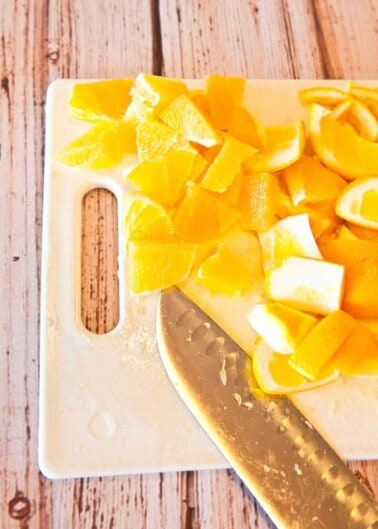 Sliced oranges on a cutting board with a knife.