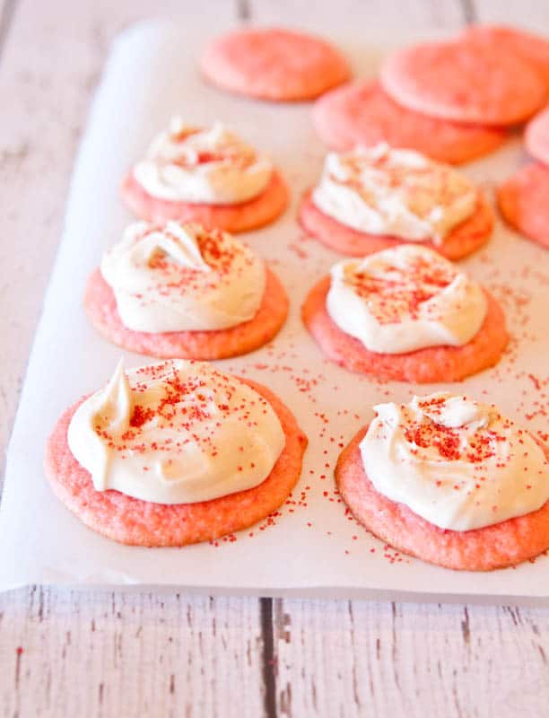 Strawberry Cake Mix Cookies with Vanilla Cream Cheese Frosting on white paper