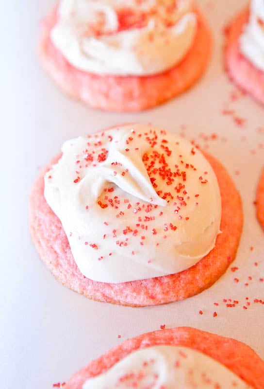 Strawberry Cake Mix Cookies with Cream Cheese Frosting on a white parchment