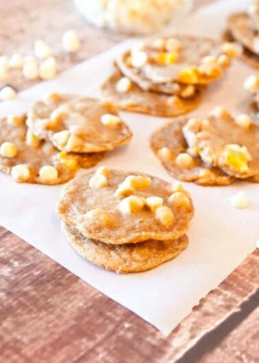 Homemade cookies with white chocolate chips on parchment paper.