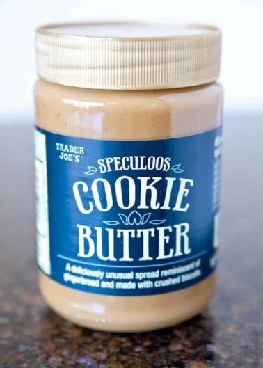 A jar of trader joe's speculoos cookie butter on a countertop.