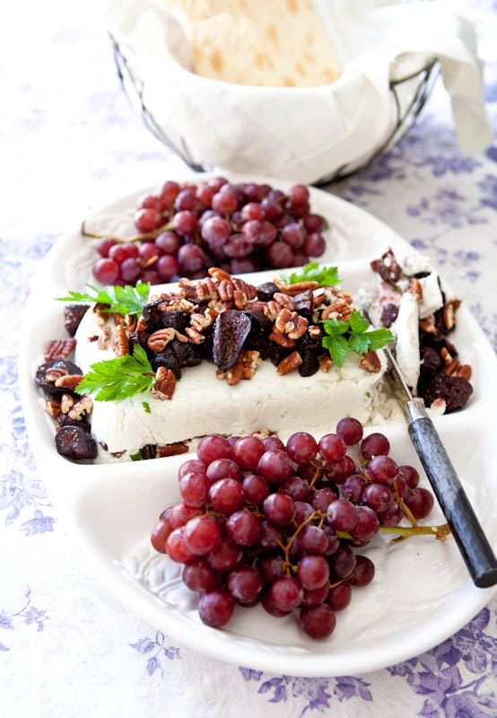 A fruit and Gorgonzola cheese plate with nuts and grapes