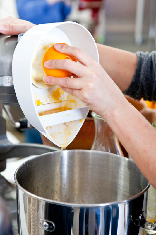 Pouring orange juice from juicer into mixing bowl