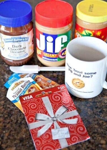 Assorted breakfast items with peanut butter jars and a gift card on a countertop.