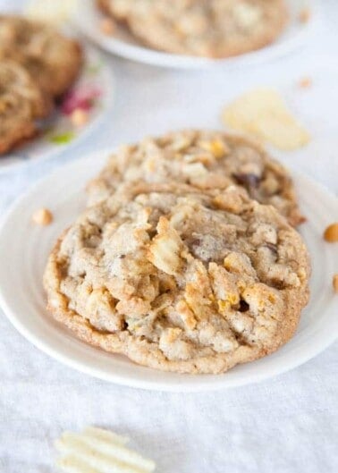 Oatmeal cookies with white chocolate chunks on a plate.