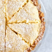 Freshly baked pie with golden crust and dusted with powdered sugar, sliced and ready to serve.