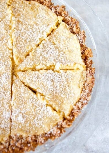 Freshly baked pie with golden crust and dusted with powdered sugar, sliced and ready to serve.