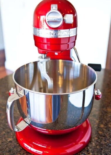 Red stand mixer on a kitchen countertop.