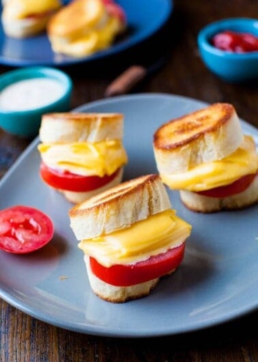 Grilled cheese sandwiches with tomato on a blue plate.