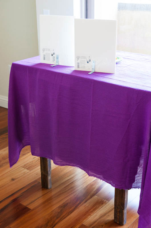 Table with purple table cloth and white panels on it