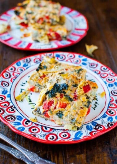 A colorful slice of vegetable frittata on a patterned plate.