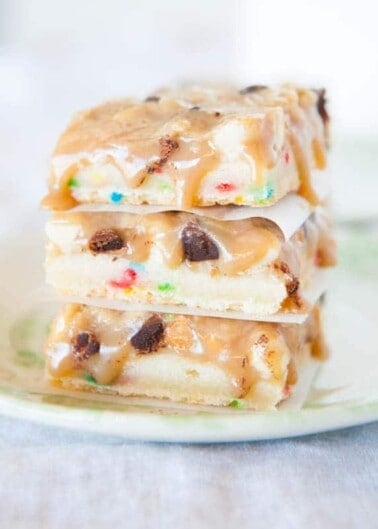 A stack of cookie dough bars with chocolate chips and sprinkles on a plate.