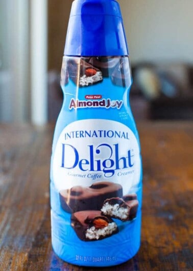 A bottle of international delight almond joy flavored coffee creamer.