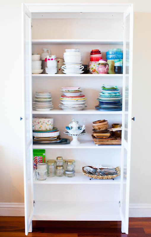 Colorful dishes inside White Hemnes Glass-Door Cabinet 