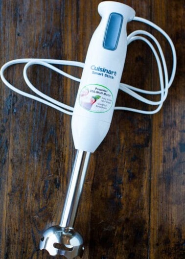 Cuisinart immersion blender lying on a wooden surface.