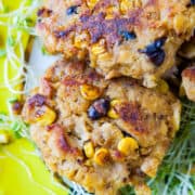 A stack of corn and bean fritters on a bed of sprouts.