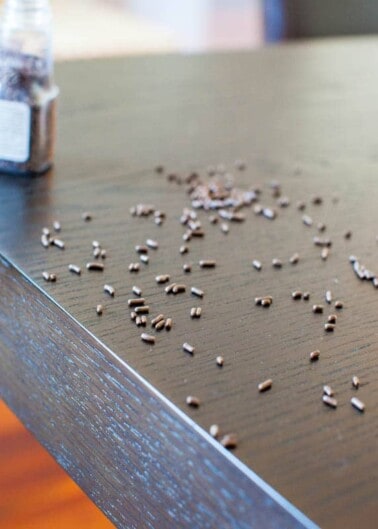 Spilled chia seeds scattered on a wooden table surface.
