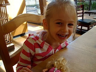 Young girl smiling at table with toys