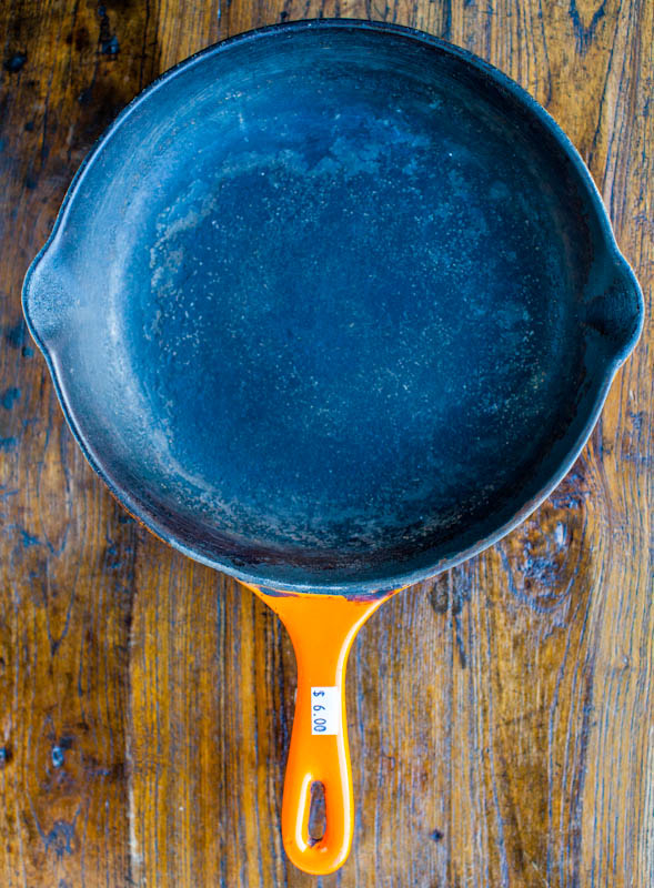 Le Creuset cast iron skillet with orange handle