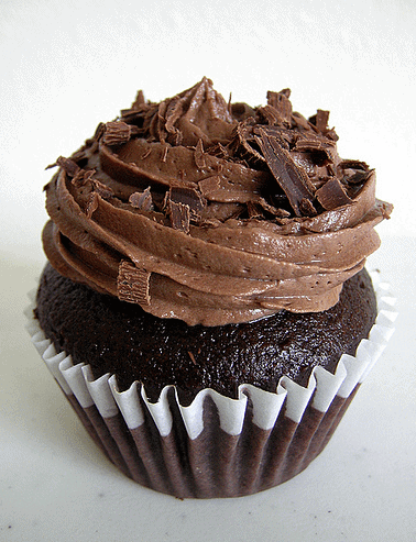 Chocolate cupcake with chocolate frosting and shavings.