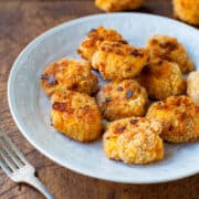 Golden-brown breaded nuggets served on a plate.