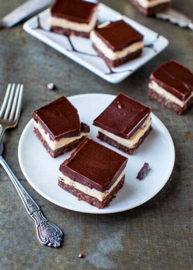 Chocolate-topped dessert bars on a plate with a vintage fork to the side.