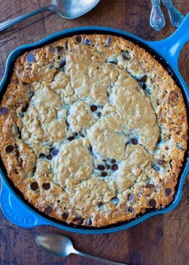 A freshly baked skillet cookie with chocolate chips, presented in a blue pan.