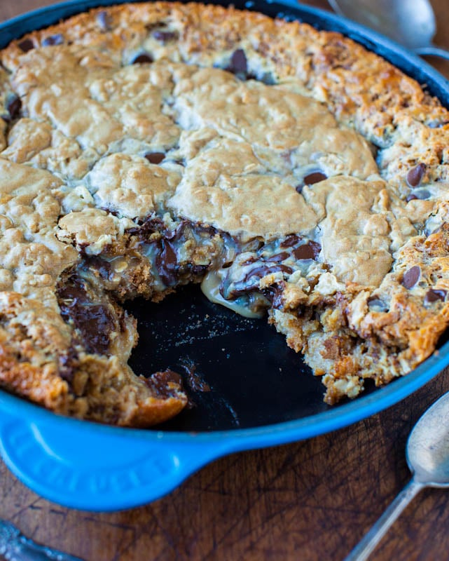 Chocolate Chip Peanut Butter Oatmeal Skillet Cookie with piece taken out showing gooey inside