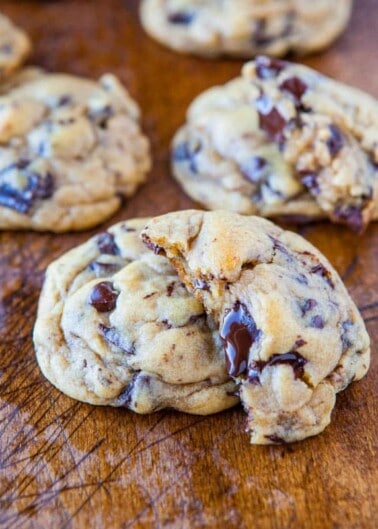 Freshly baked chocolate chip cookies on a wooden surface.