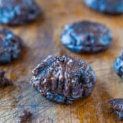 Freshly baked chocolate cookies on a wooden surface.