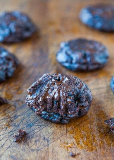 Freshly baked chocolate cookies on a wooden surface.