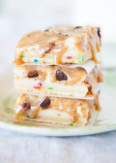 A stack of colorful cookie dough bars on a plate.