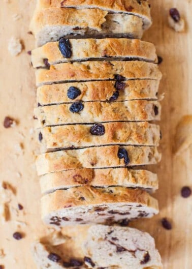 Sliced raisin bread loaf on a wooden surface.