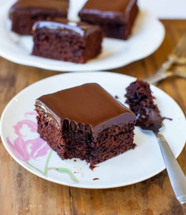 The Best Chocolate Cake with Chocolate Ganache on a white plate with a fork