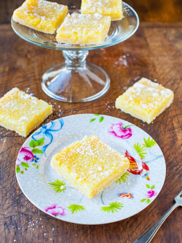 The Best Lemon Bars on a white flowered plate on a wooden table