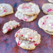 Strawberry and white chocolate chip cookies on a wooden surface.