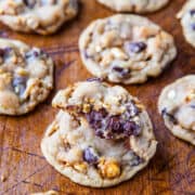 Homemade chocolate chip cookies with nuts on a wooden surface.