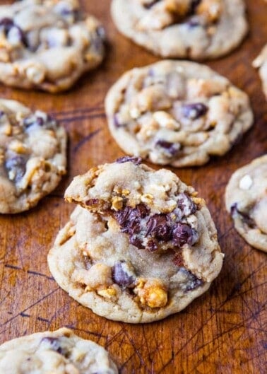 Homemade chocolate chip cookies with nuts on a wooden surface.