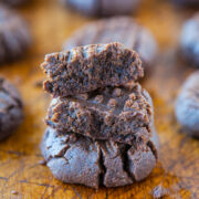 Close-up of a stack of chocolate truffles on a wooden surface.
