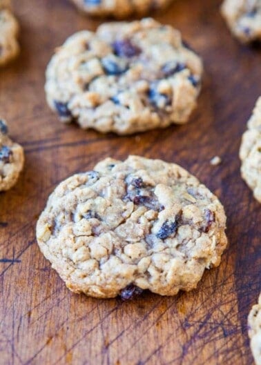 Freshly baked oatmeal raisin cookies on a wooden surface.