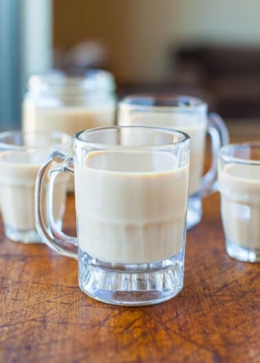 Four glasses of creamy beverage on a wooden table.