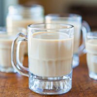Glasses of milk on a wooden table.