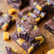 Sliced caramel brownies on a wooden surface.
