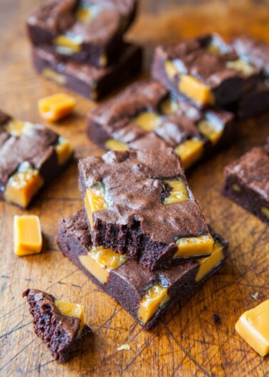 Sliced caramel brownies on a wooden surface.