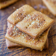 Homemade square biscuits sprinkled with sugar crystals on a wooden surface.