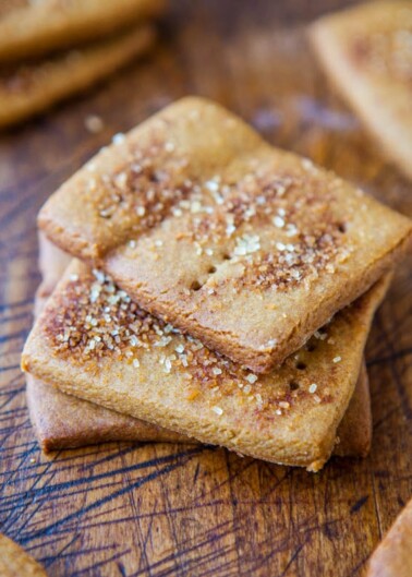 Homemade square biscuits sprinkled with sugar crystals on a wooden surface.