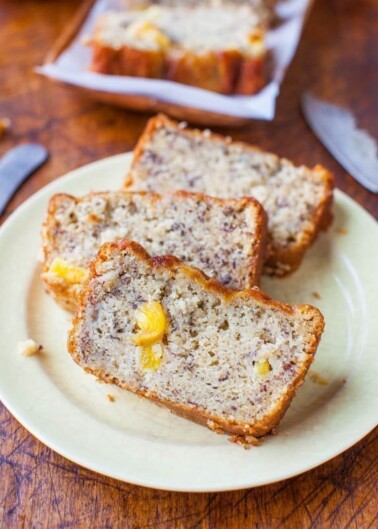 Slices of banana bread with visible banana chunks on a plate.
